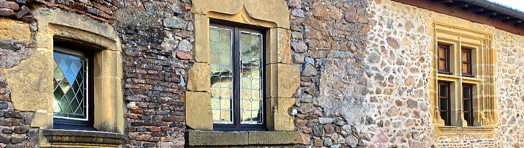 Fenêtres sur une ancienne façade, à Crozet (42)